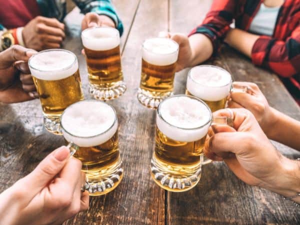 a group of people cheerings with beer glasses